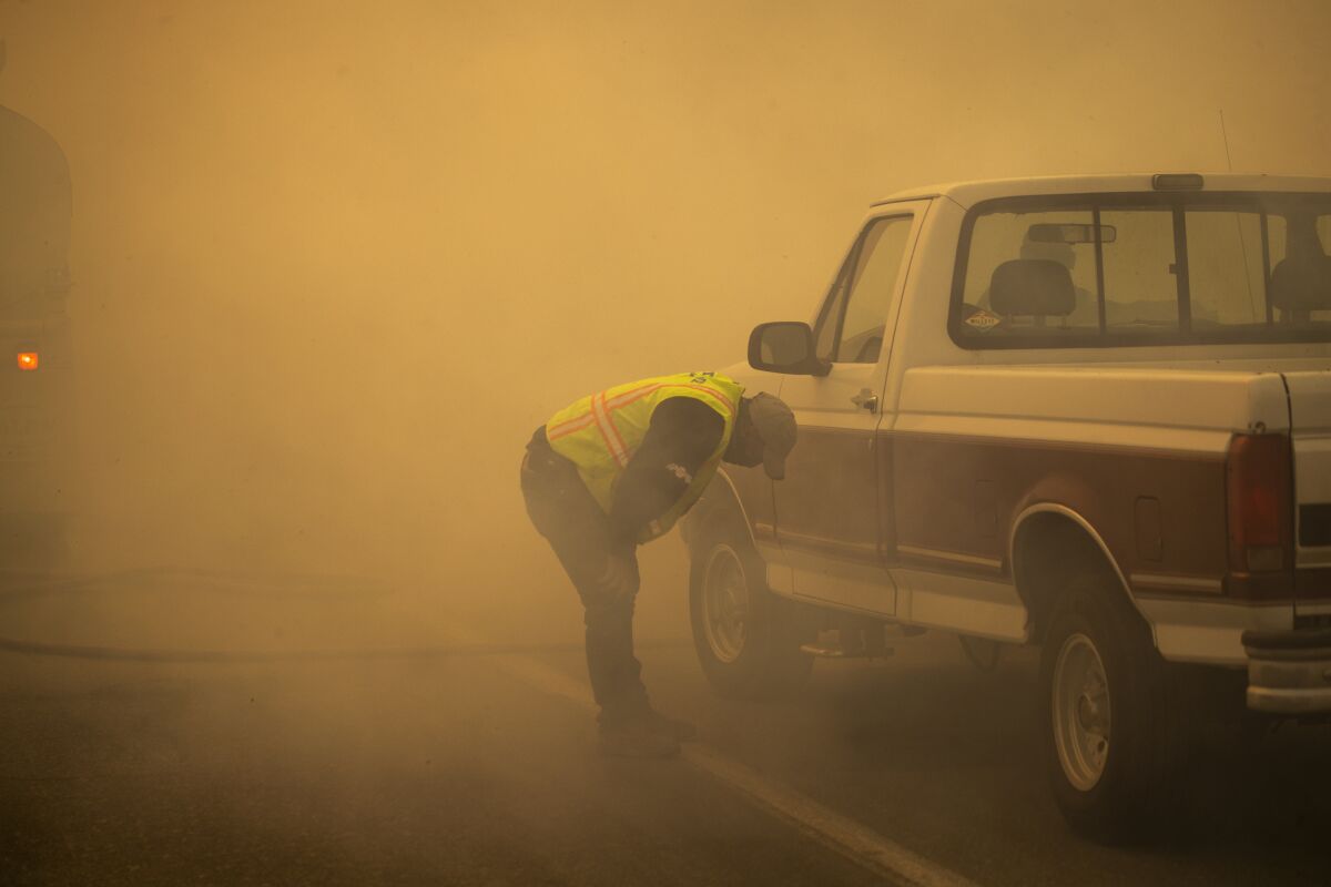 A water truck operator is overcome with smoke after running through the advancing Silverado fire in Orange County.