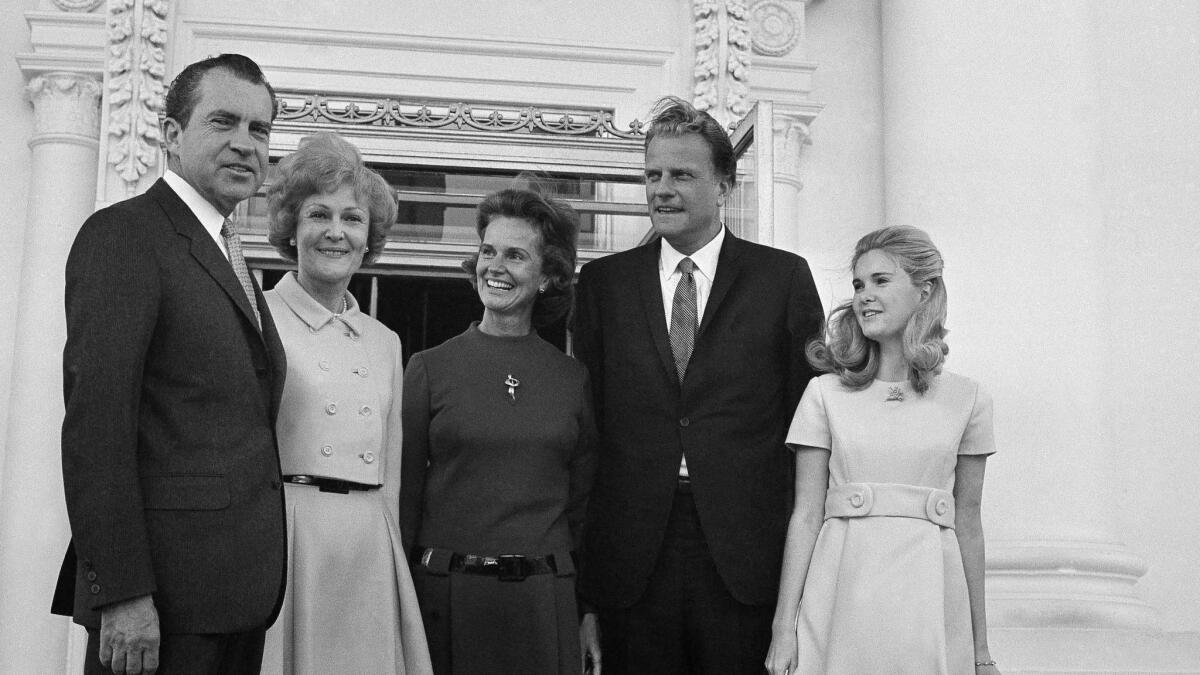 President Richard Nixon and Pat Nixon stand at the White House North Portico in 1969 with Billy Graham and his wife Ruth after a church service in the East Room. At right is Nixon's daughter Tricia.