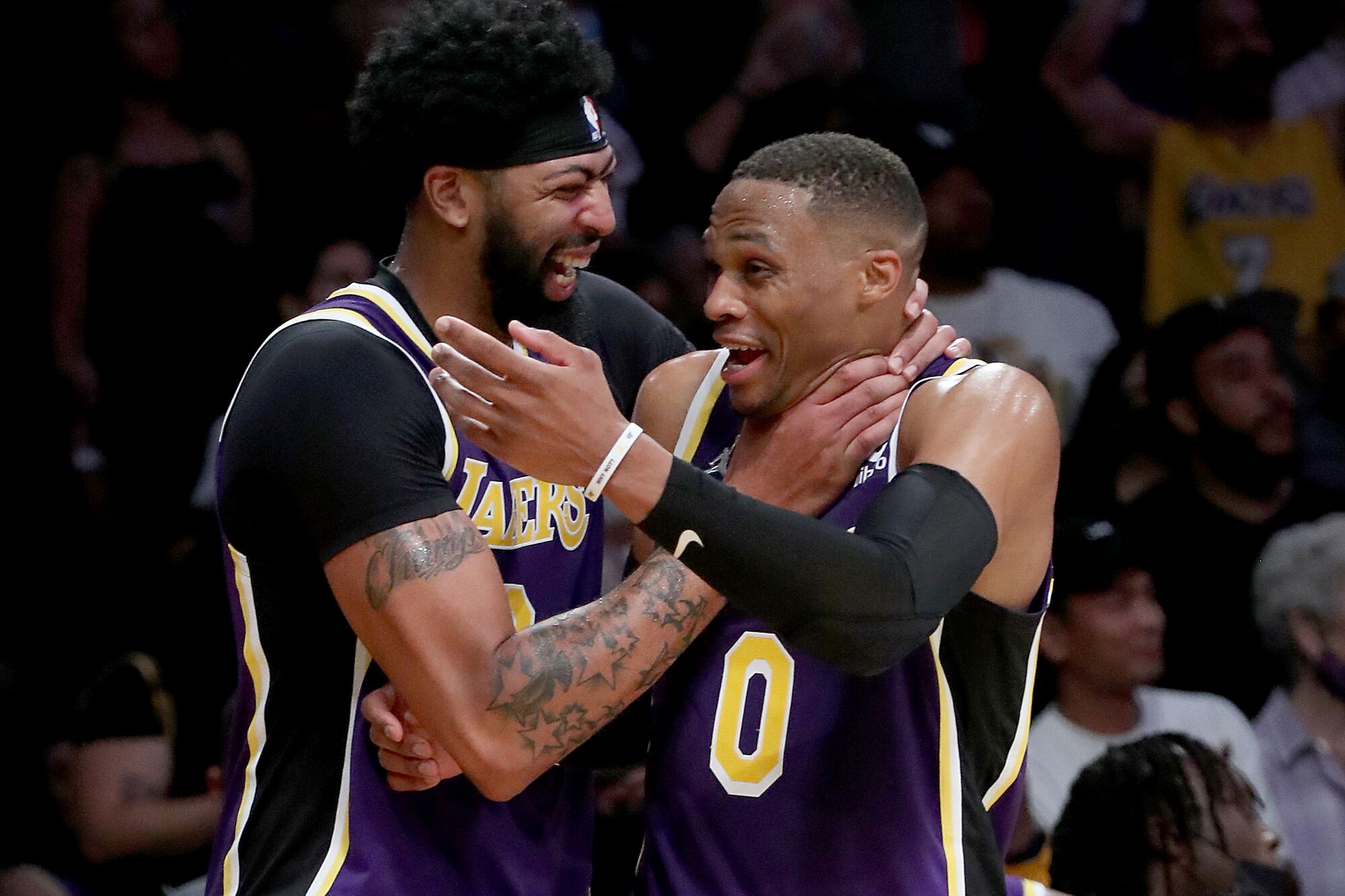 Anthony Davis put his hands around Russell Westbrook's neck and smiles.