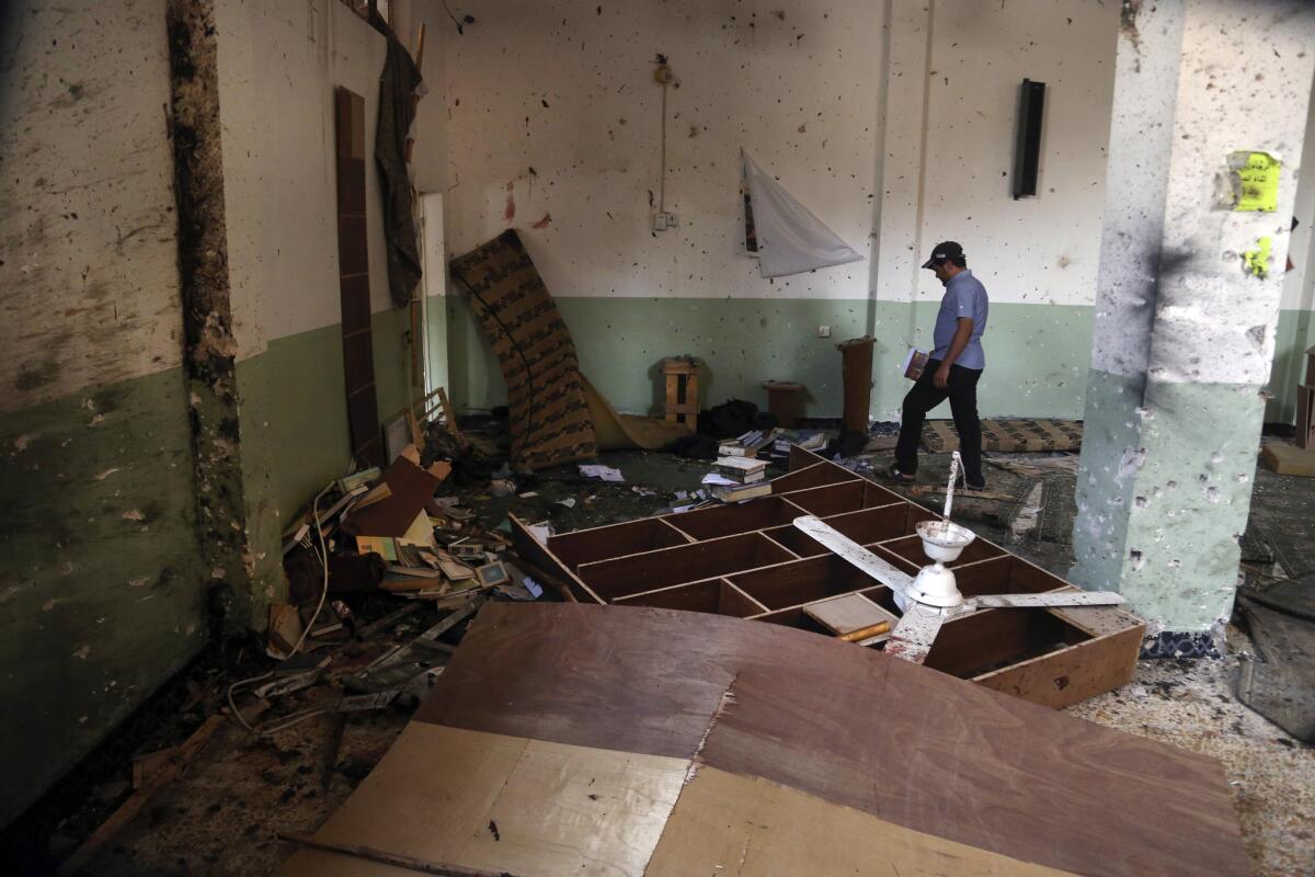 A man inspects damage inside a mosque in New Baghdad, Iraq, one of the sites hit by a wave of attacks Aug. 25 that killed and wounded scores of people.