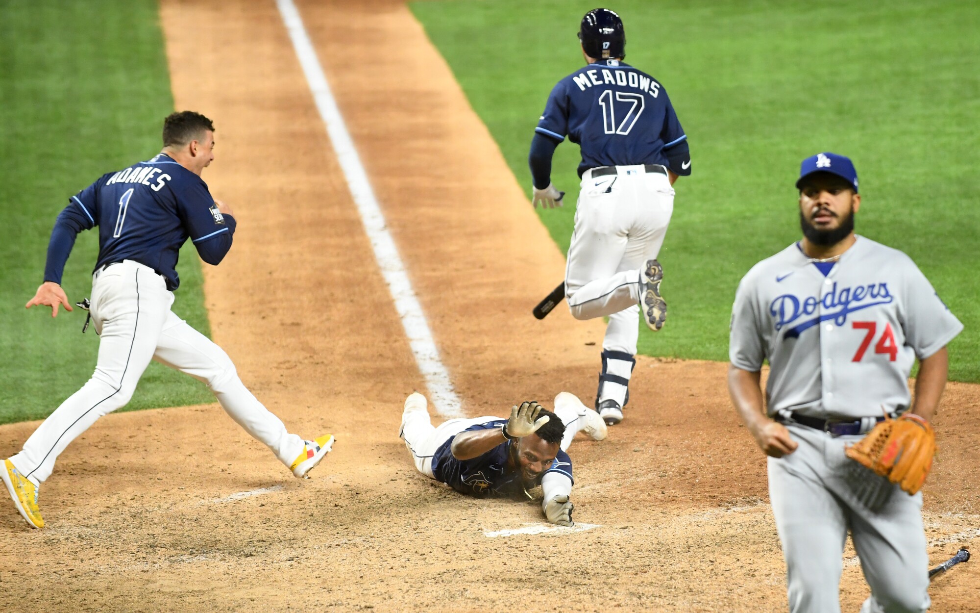 Tampa Bay's Randy Arozarena pounds home plate after sliding in to score the winning run.