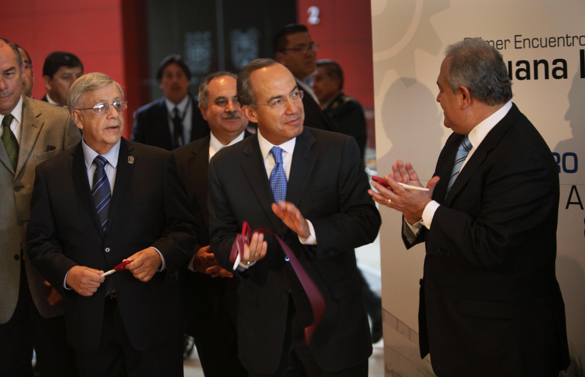 El presidente mexicano Felipe Calderón, en el centro, corta la cinta para inaugurar la conferencia 
