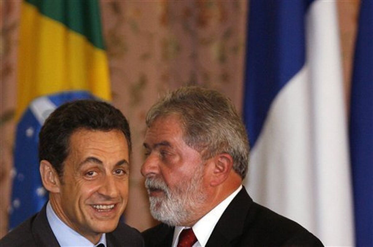 French President Nicolas Sarkozy, left, listens to Brazil's President Luiz Inacio Lula da Silva after signing bilateral agreements in Rio de Janeiro, Tuesday, Dec. 23, 2008. Sarkozy is on a two-day official visit to Brazil. (AP Photo/Andre Mourao)