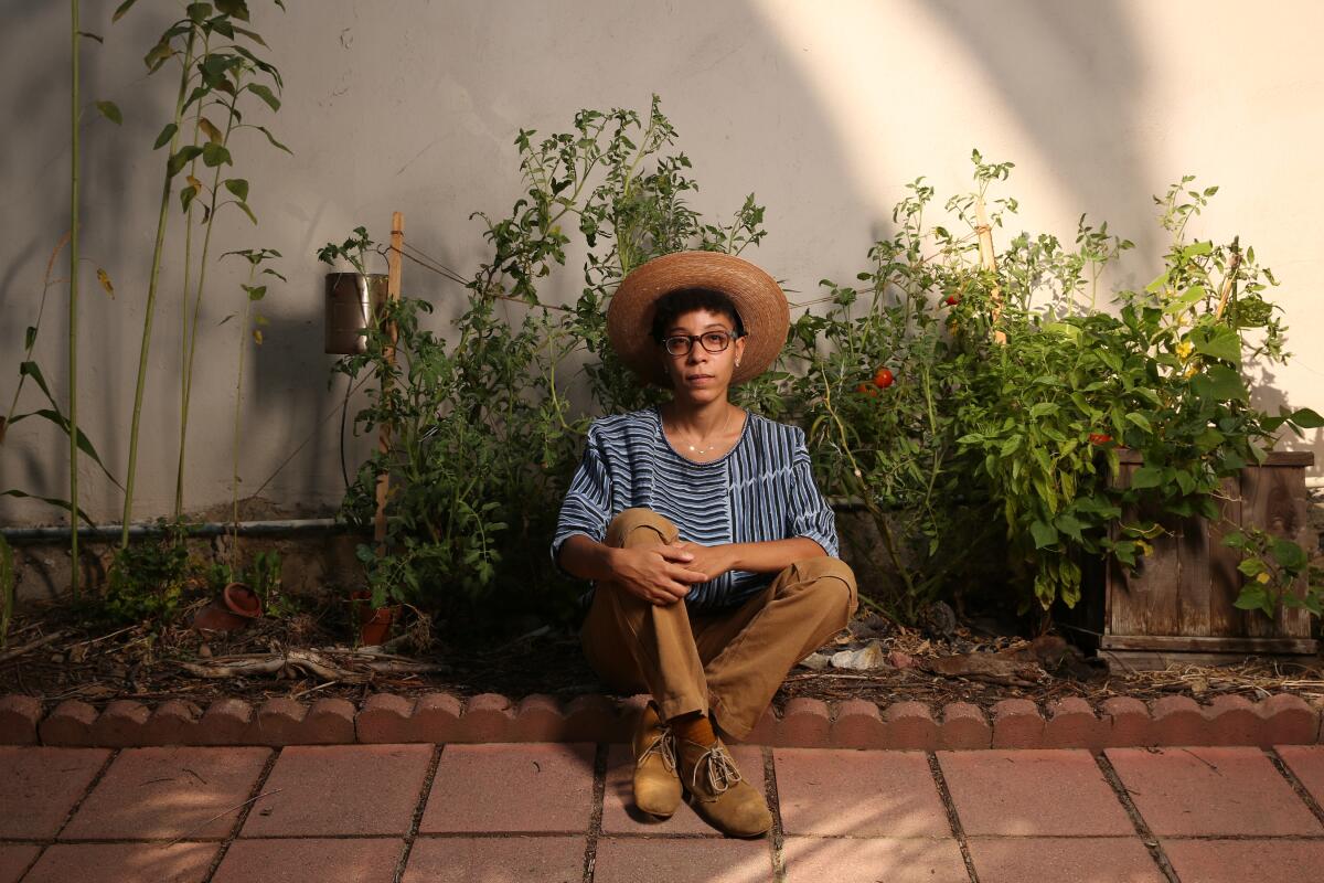  Jamie Williams sits with the garden she grew outside of her apartment. 