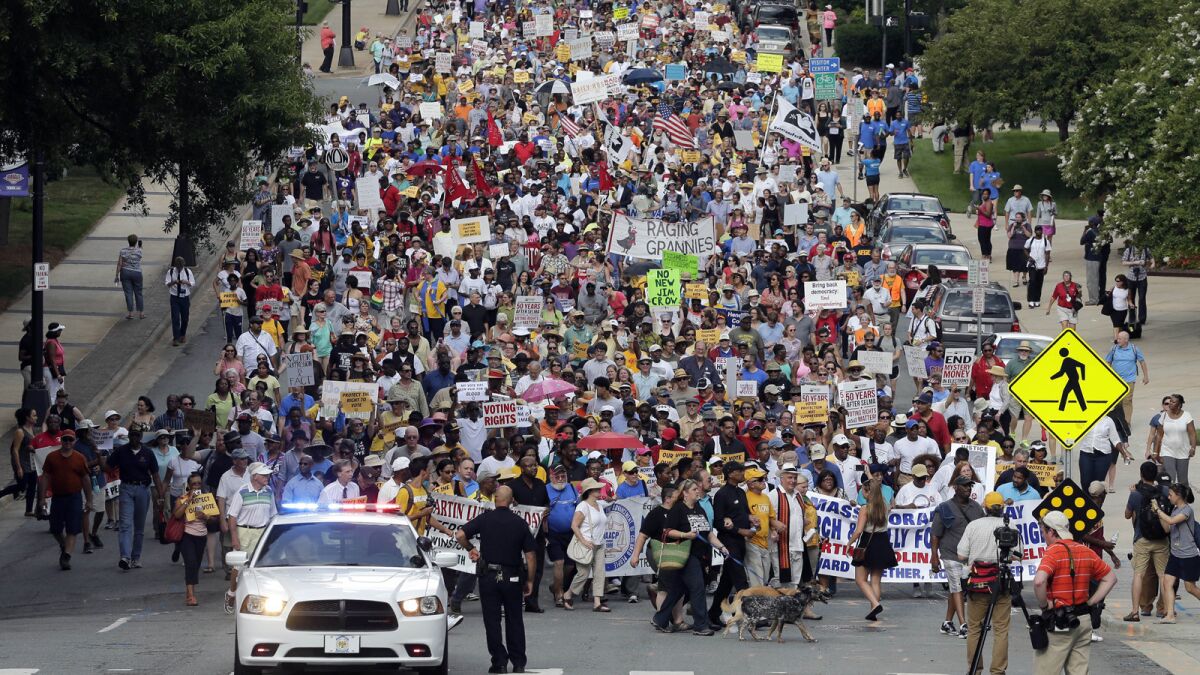 Demonstrators march through the streets of Winston-Salem, N.C., after the beginning of a federal voting rights trial.