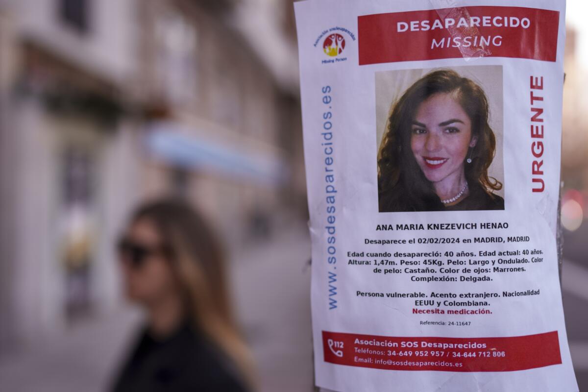 A missing poster with a woman's face is displayed on a streetlight.