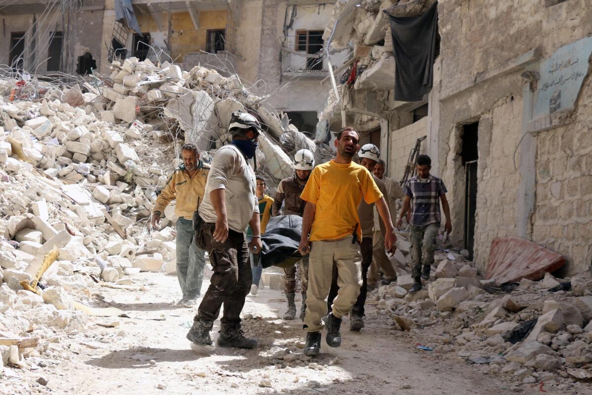 Syrian Civil Defense workers evacuate a body after a government airstrike on Tuesday in the northern city of Aleppo.