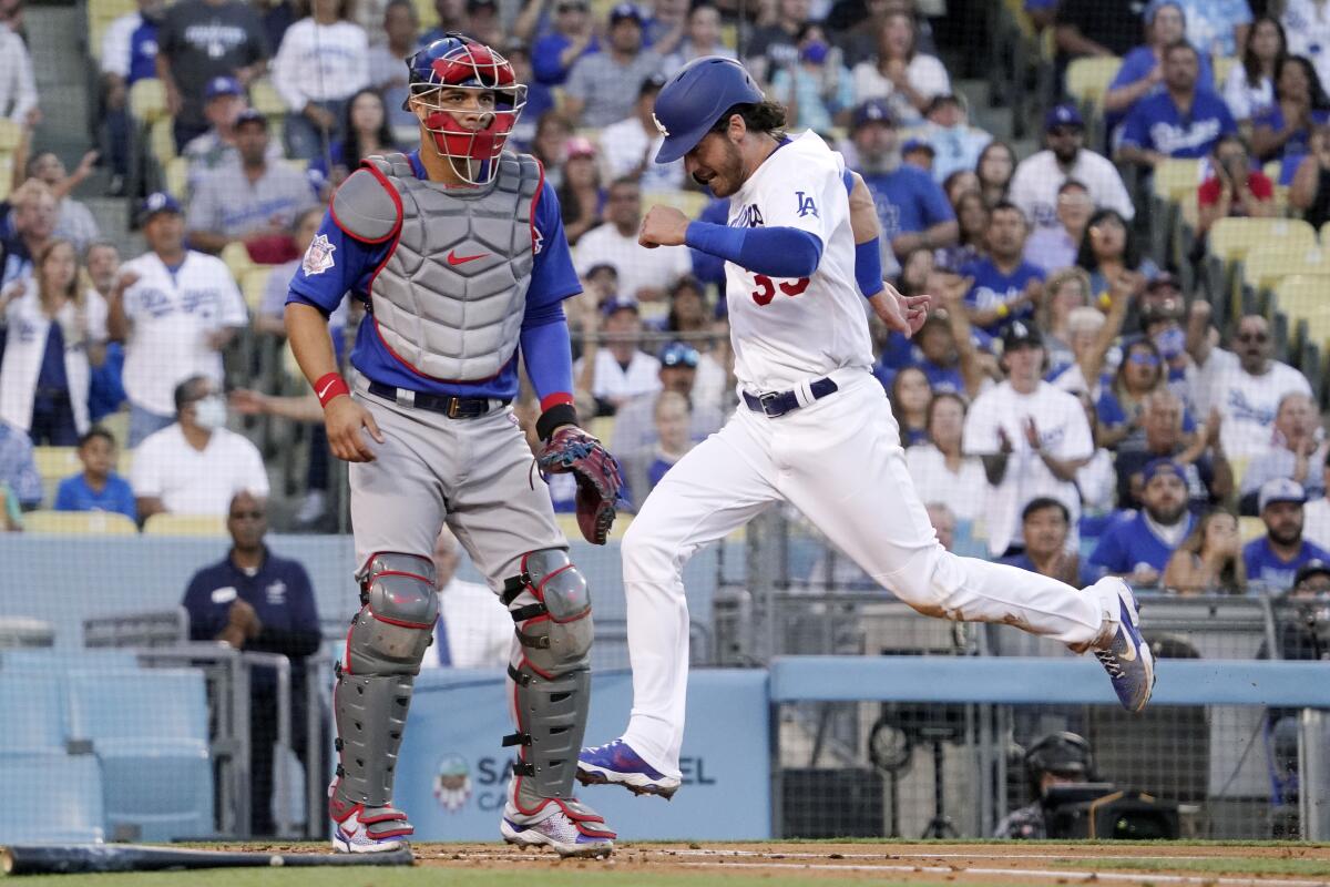 Cody Bellinger scores a run in front of Cubs catcher Willson Contreras during the Dodgers' win on Friday.