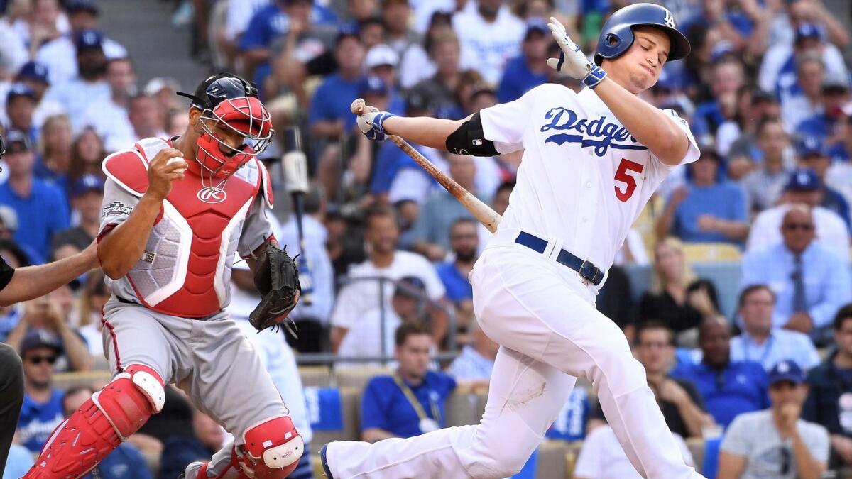 Corey Seager of the Dodgers strikes out in the eighth inning of Game 3 of a National League division series as Nationals catcher Jose Lobaton celebrates.