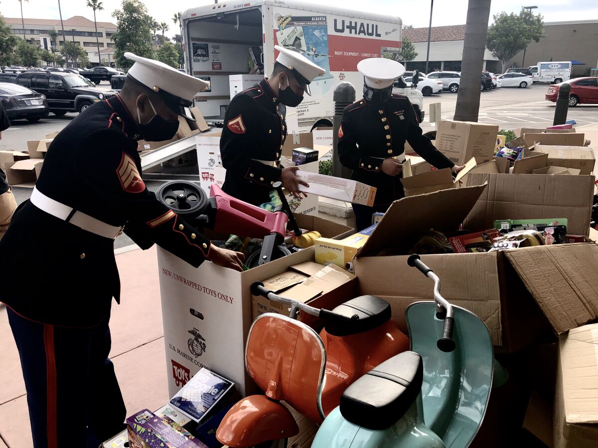 Sgt. Federico Sanchez (l) and fellow Marines sort Toys for Tots donations by an anonymous philanthropist.