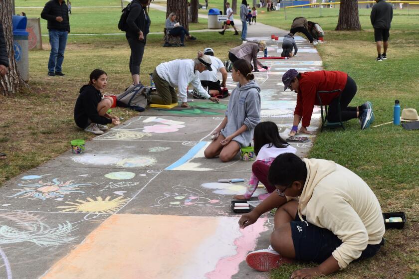 Contestants working on their drawings in the 2024 Chalk It Up sidewalk chalk art contest in Rancho Bernardo Community Park.