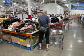 A shopper surveys stacks of clothing on a sales table in a Costco warehouse Thursday, June 22, 2023, in Colorado Springs, Colo. On Friday, the Commerce Department issues its May report on consumer spending. The report contains a measure of inflation that is closely watched by the Federal Reserve. (AP Photo/David Zalubowski)