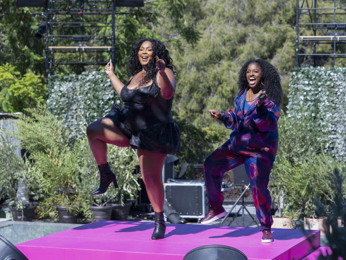 Two women dancing on a pink stage