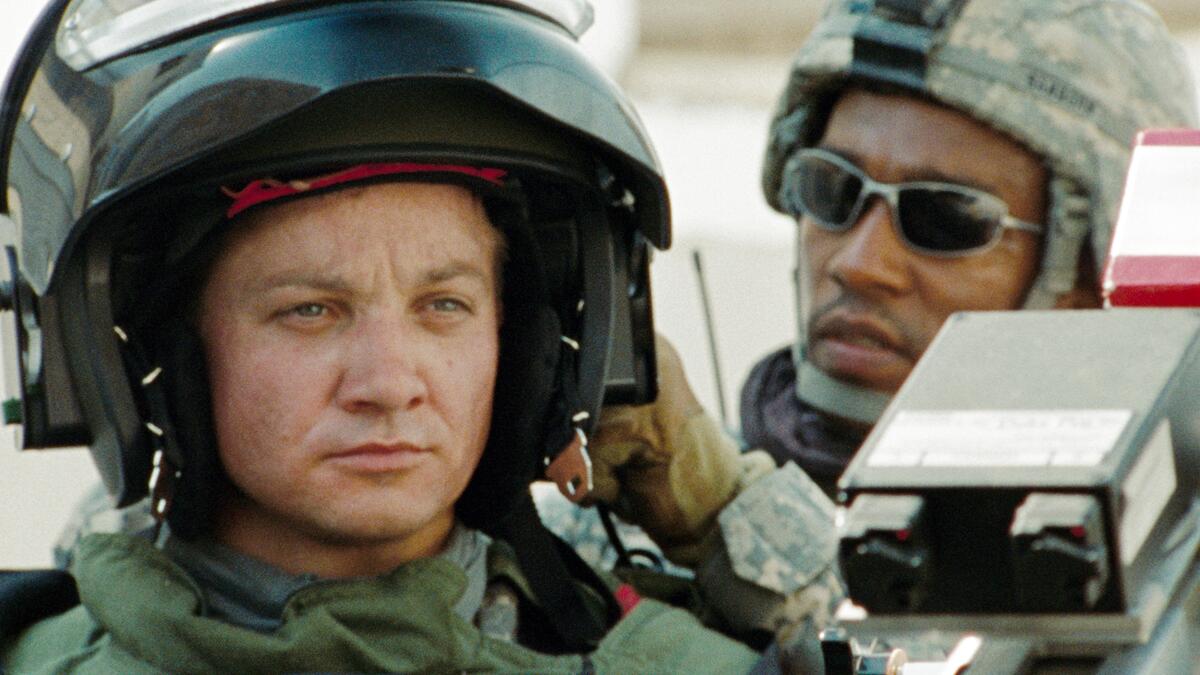 Jeremy Renner wears a bomb resistant helmet as Anthony Mackie looks on in “The Hurt Locker”