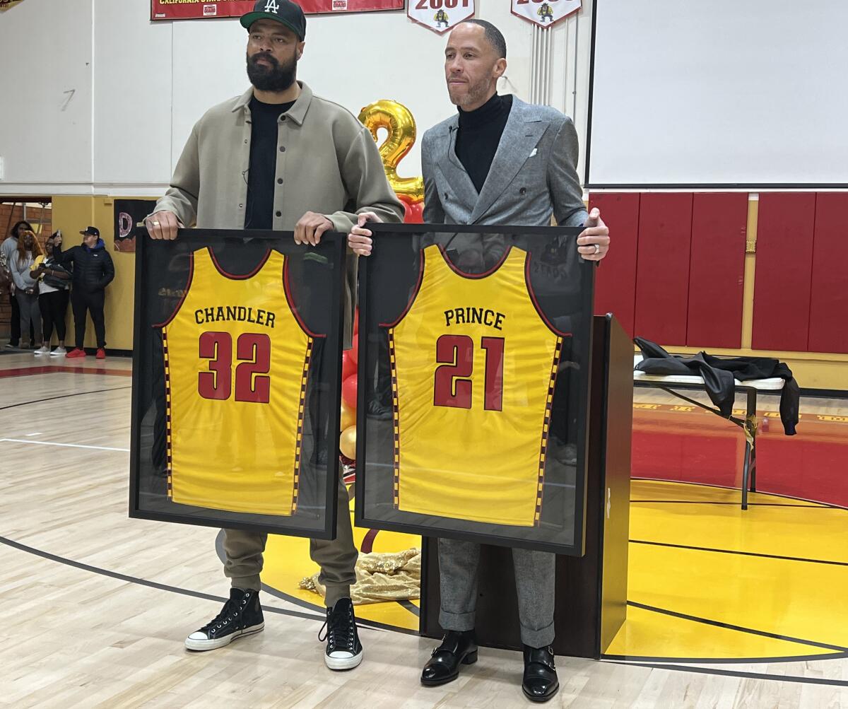 Tyson Chandler and Tayshaun Prince hold up their framed Dominguez High jerseys