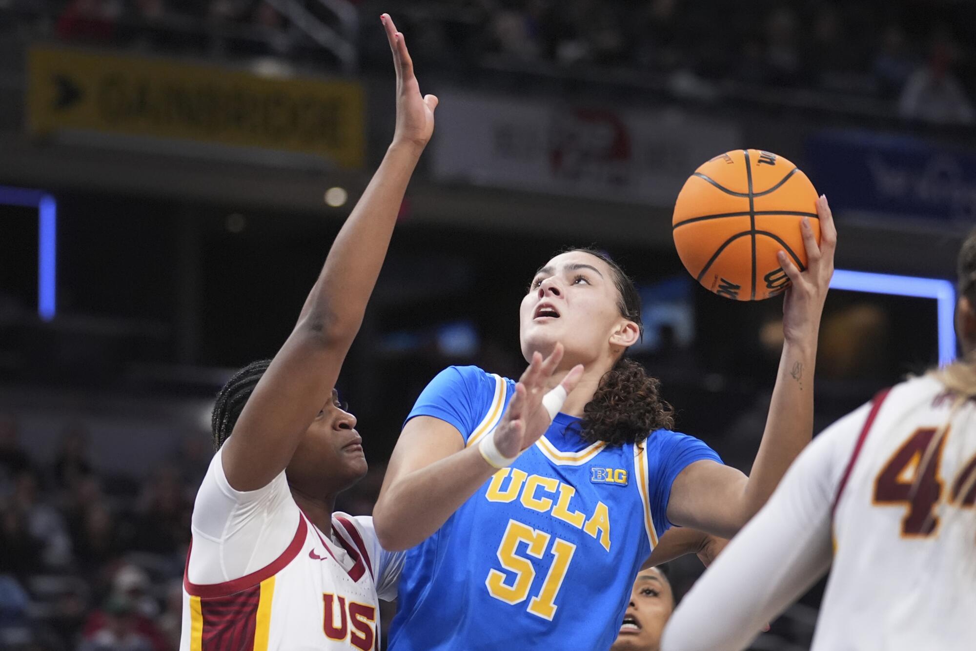 UCLA merkezi Lauren Betts, ikinci yarıda USC merkezi Clarice Akunwafo üzerinden ateş ediyor.