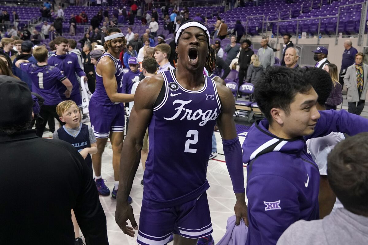 TCU's Emanuel Miller shouts in celebration as fans rush the court after the Horned Frogs' win Feb. 26, 2022. 