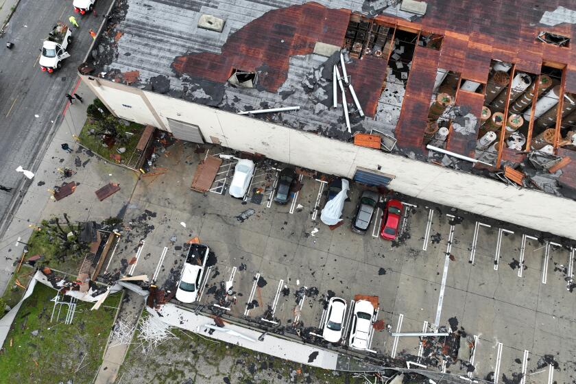 Montebello, CA - March 22: Crews start to clean up debris after a strong microburst -- which some witnesses dubbed a possible tornado -- heavily damaged several cars and buildings, including the roof of the Royal Paper Box Company, shown in photo, in Montebello Wednesday, March 22, 2023. Video from the scene showing portions of rooftops being ripped off industrial structures and debris swirling in the air. The National Weather Service on Tuesday night issued a brief tornado warning in southwestern Los Angeles County, but it was allowed to expire after about 15 minutes when weather conditions eased. There was no such warning in place late Wednesday morning when the powerful winds hit Montebello, near the area of Washington Boulevard and Vail Avenue. (Allen J. Schaben / Los Angeles Times)