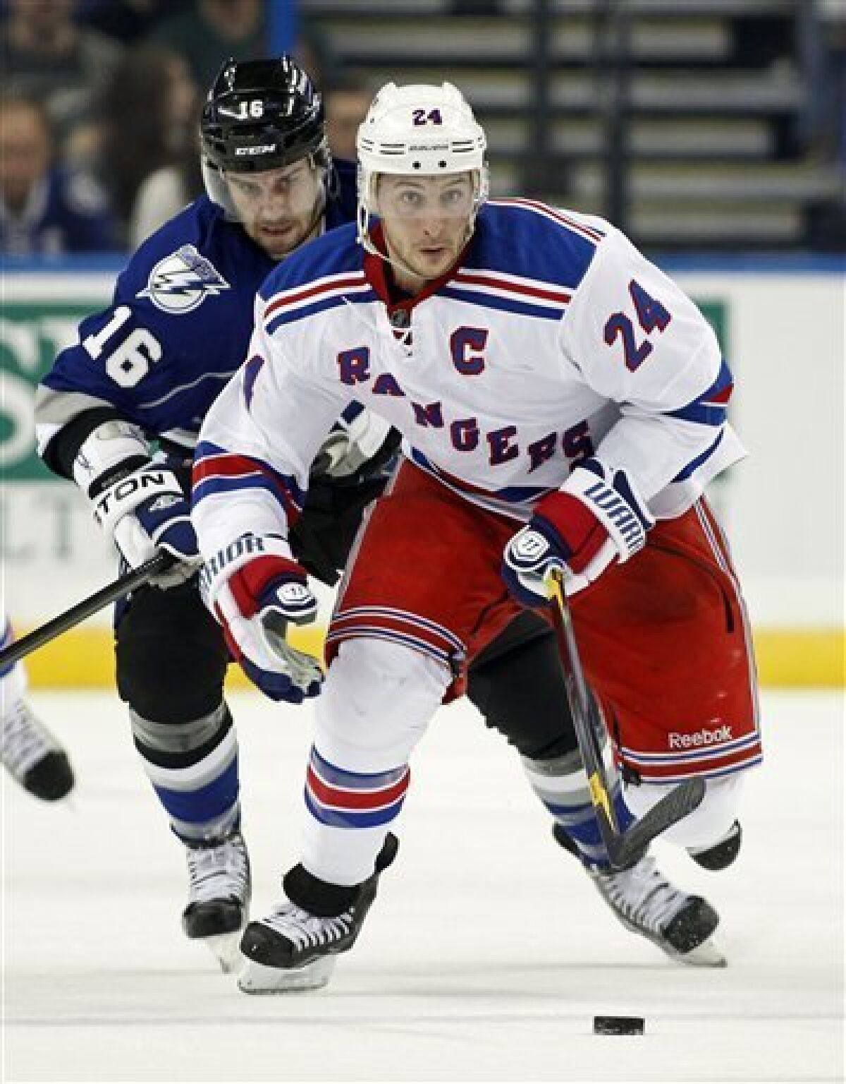 New York Rangers' Ryan Callahan (24) brings the puck up the ice in front of Tampa Bay Lightning's Teddy Purcell during the first period of an NHL hockey game on Saturday, Dec. 3, 2011, in Tampa, Fla. (AP Photo/Mike Carlson)