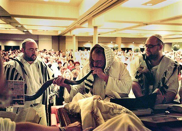 Philip Berg, flanked by sons Michael, left, and Yehuda, blows the traditional ram's horn at Rosh Hashana rites for kabbalah students in 2001.