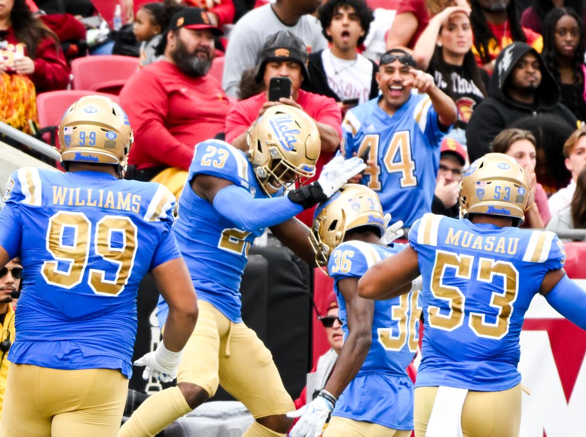UCLA defensive back Kenny Churchwell III celebrates a fumble recovery for a touchdown by defensive back Alex Johnson.