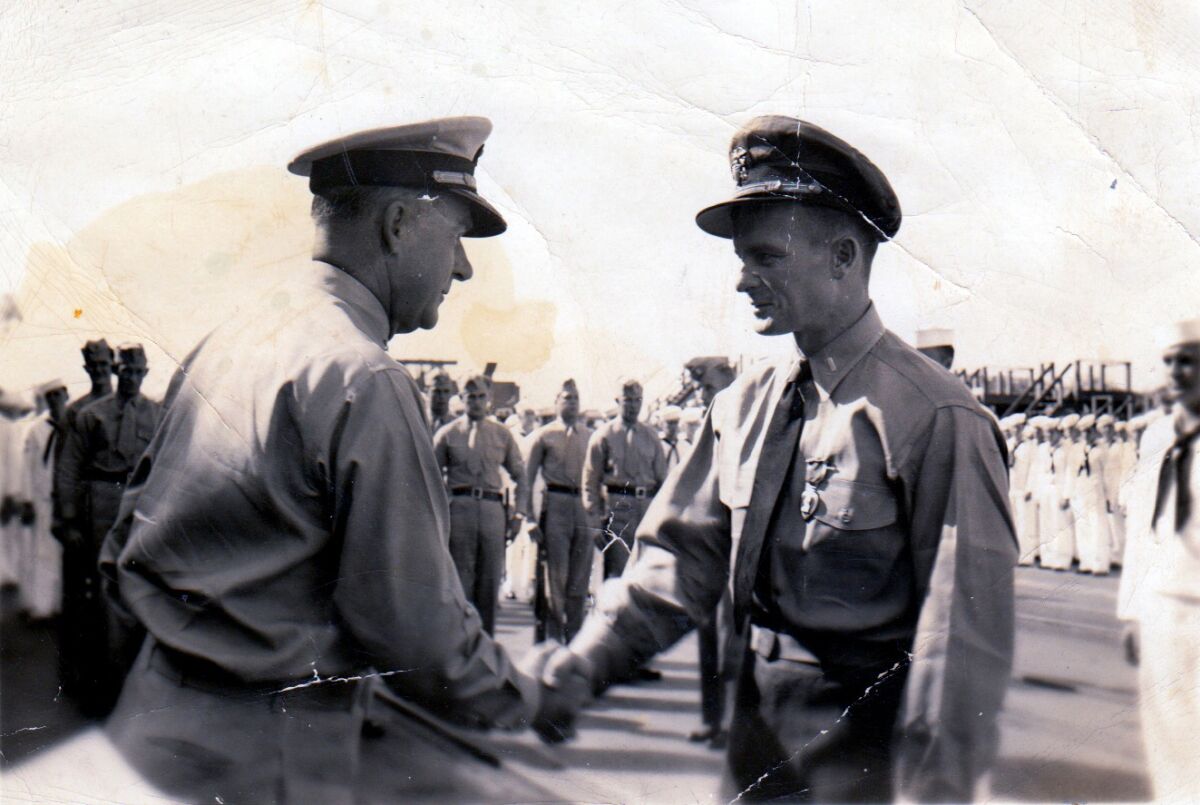 Navy Lt. J.G. George Coburn, right, receives the Purple Heart medal in 1945.