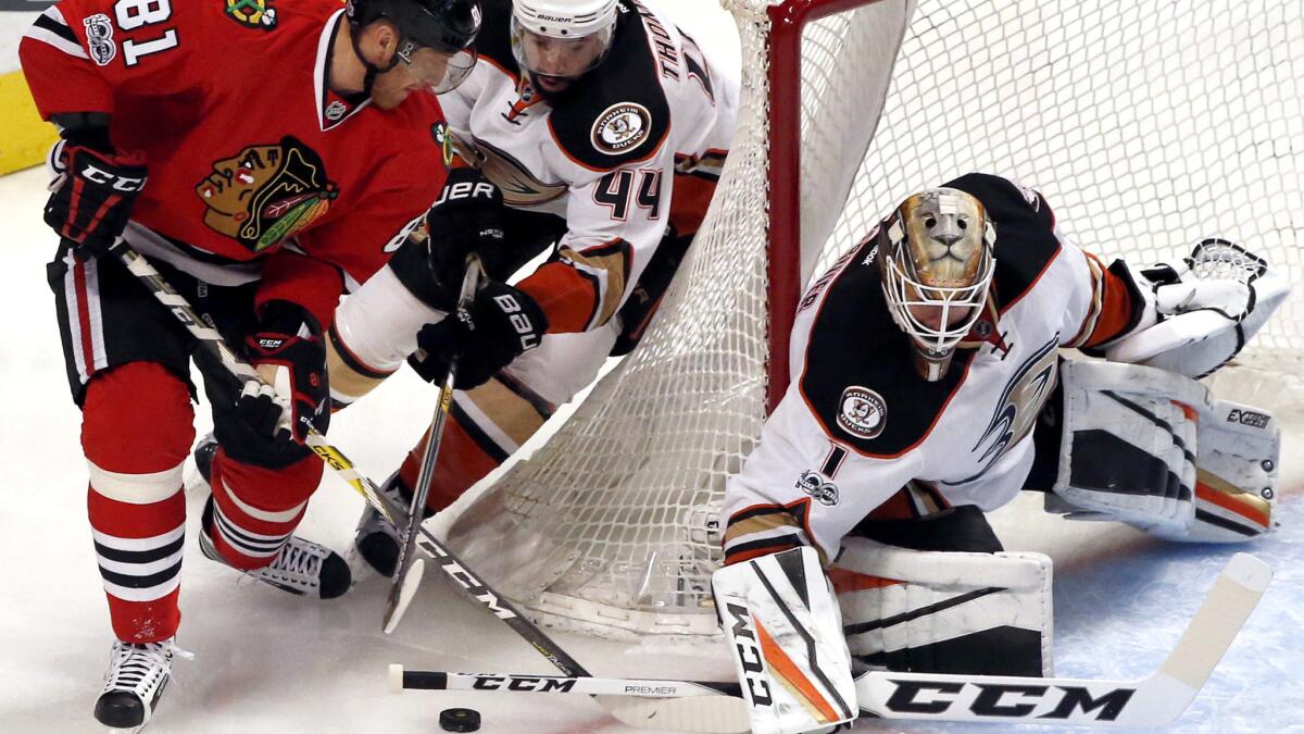 Ducks goalie Jonathan Bernier blocks a shot by Blackhawks right wing Marian Hossa, who is defended by Ducks center Nate Thompson, during the first period Thursday night.