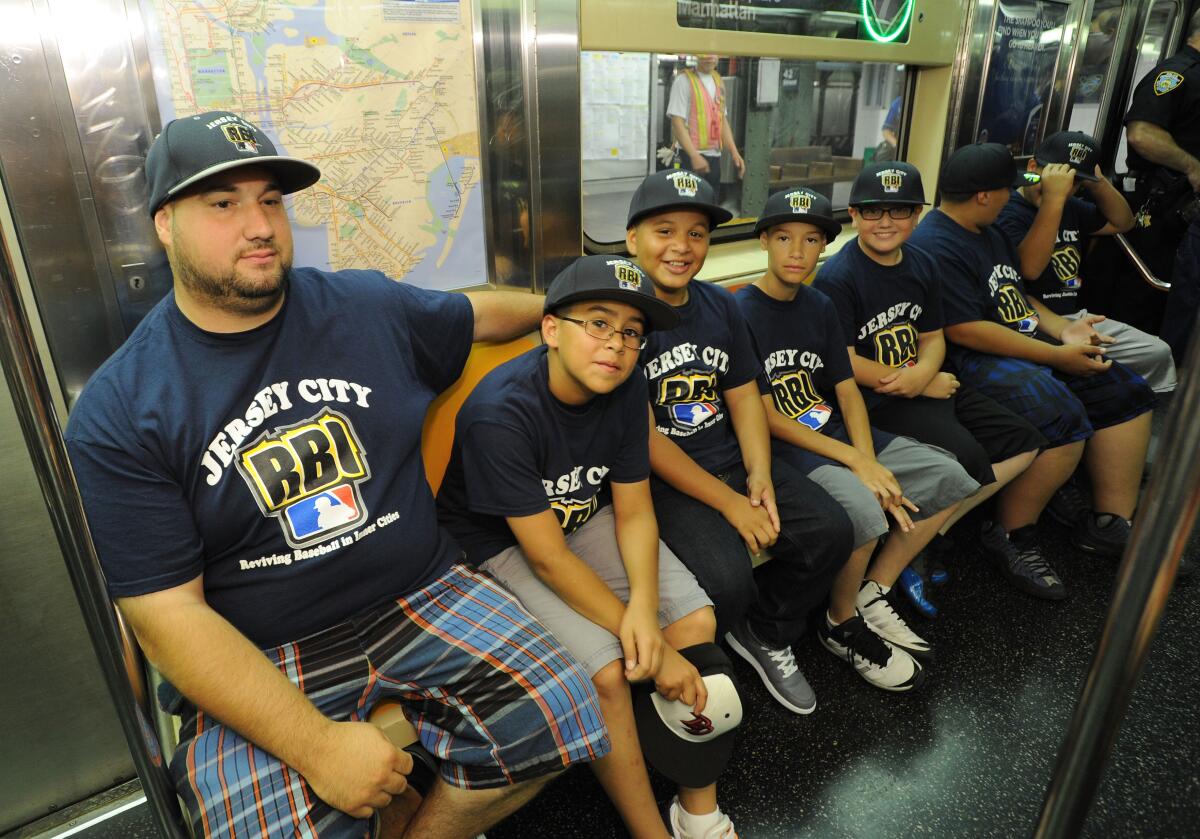 Children and their coach ride a subway train in New York on their way to a Reviving Baseball in Inner Cities (RBI) event in 2013.