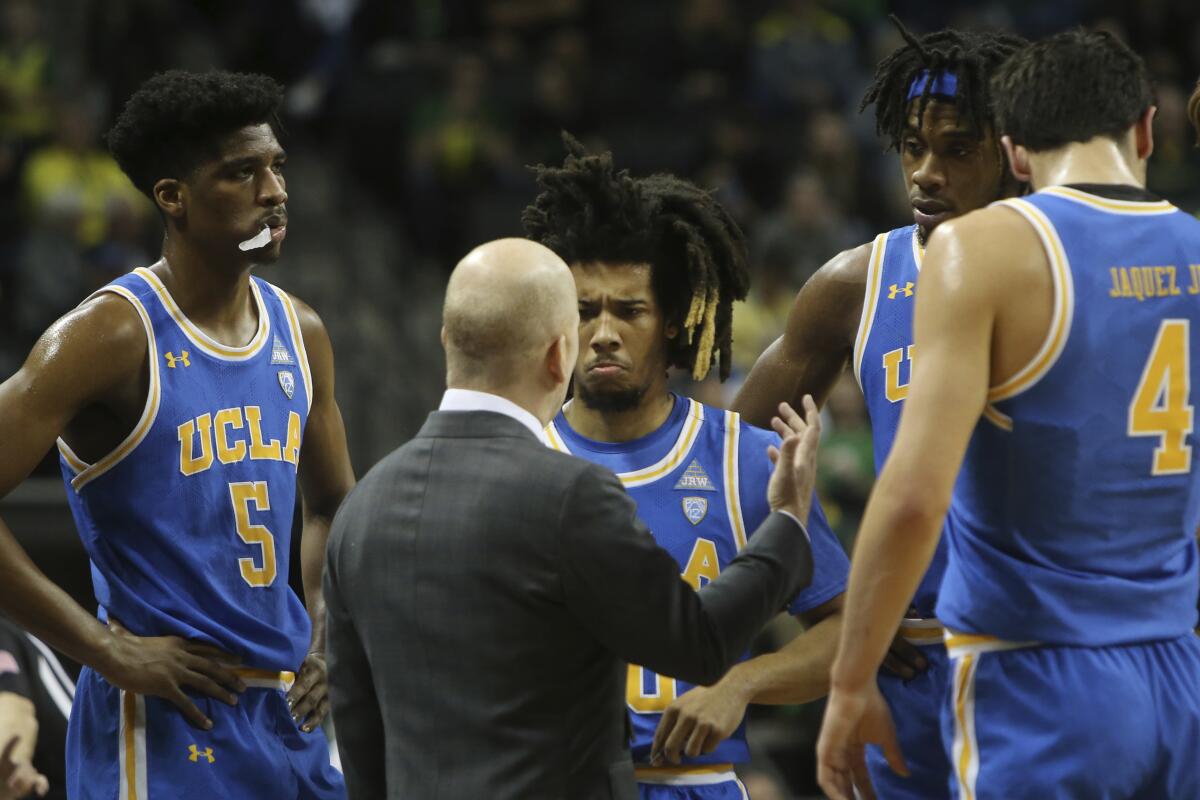 UCLA head men basketball coach Mick Cronin, center, talks to his team including Chris Smith, left, Tyger Campbell, Jalen Hill and Jaime Jaquez Jr. during a game against Oregon in Eugene.