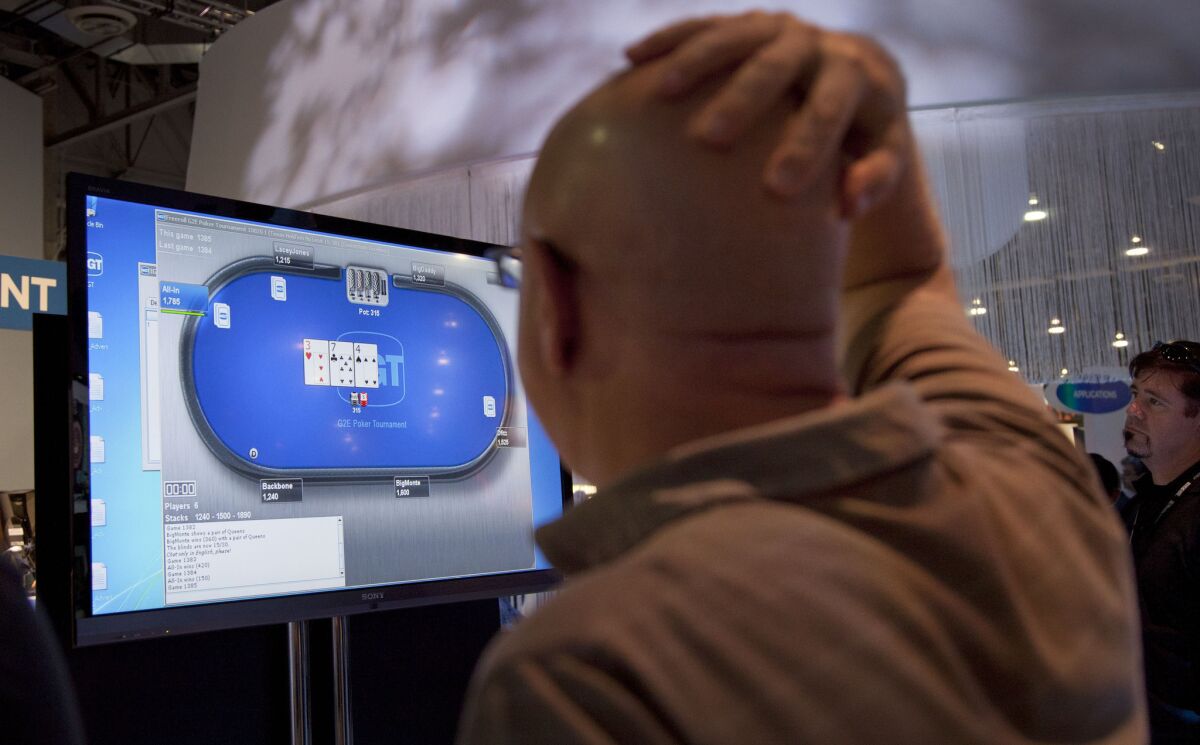 Casino industry representatives and exhibitors watch an online poker game at the industry's G2E gaming conference in Las Vegas.