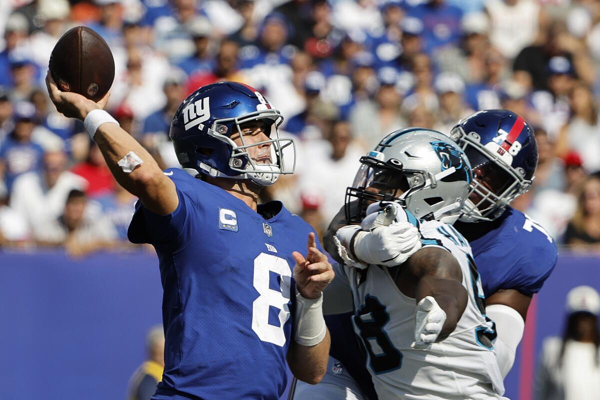 New York Giants quarterback Daniel Jones throws under pressure from Carolina Panthers' Marquis Haynes Sr.