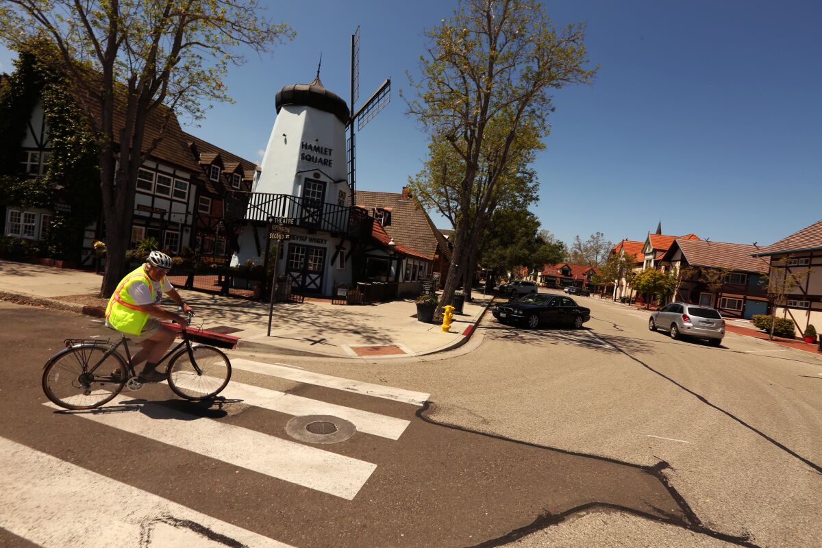 Chuck Stacy, 72, bikes down an empty street in downtown Solvang in April.