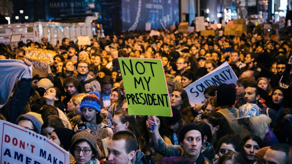People protest the presidential election results in New York in 2016. One sign reads "Not my president."