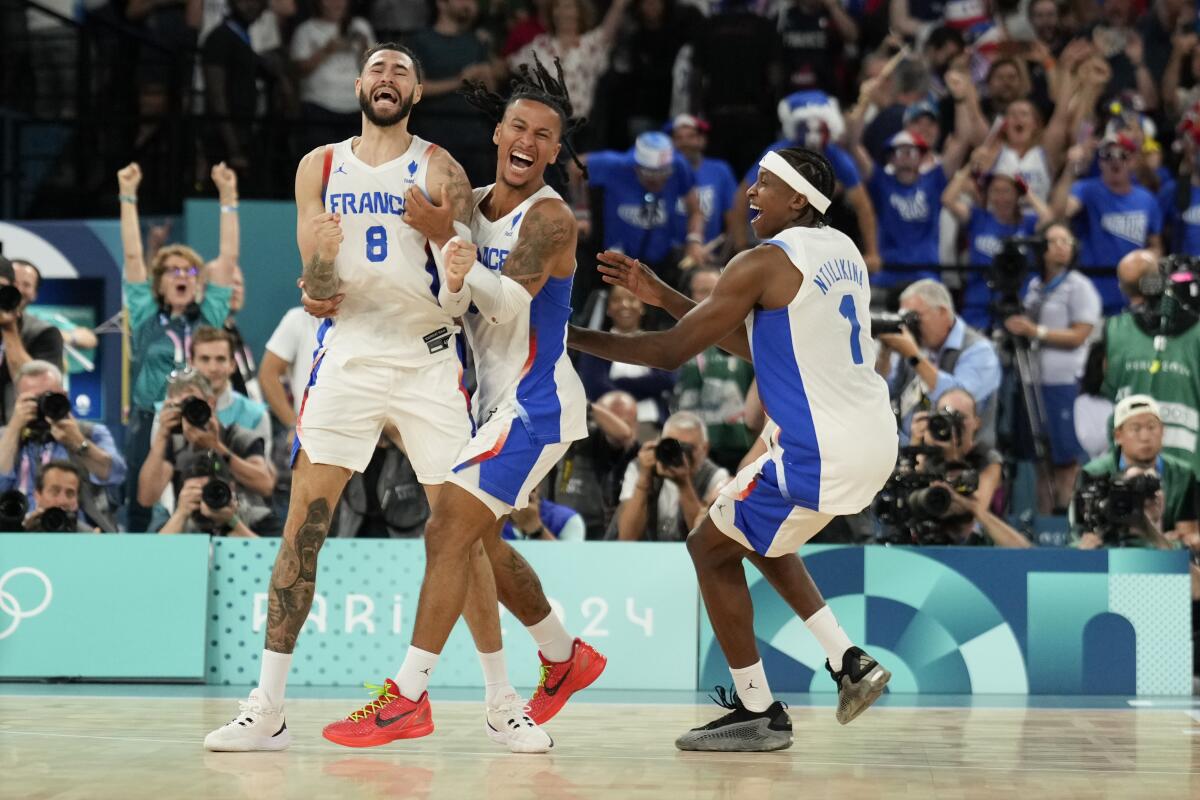 Isaia Cordinier, Matthew Strazel, and Frank Ntilikina, of France, celebrate beating Germany 