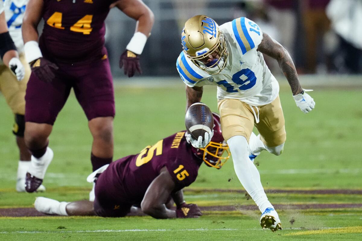 UCLA's Kazmeir Allen (19) breaks away from Arizona State defensive back Khoury Bethley (15) for a long gain Nov. 5, 2022.