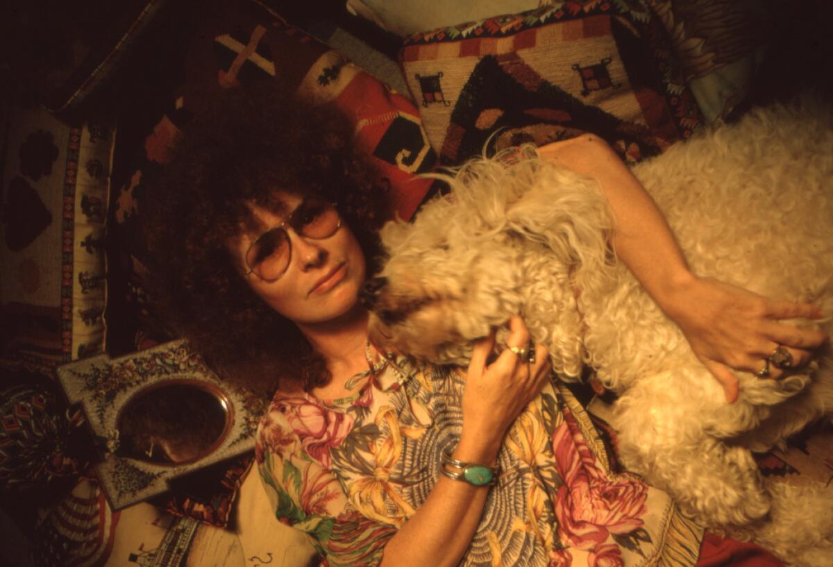 A woman poses with her dog.