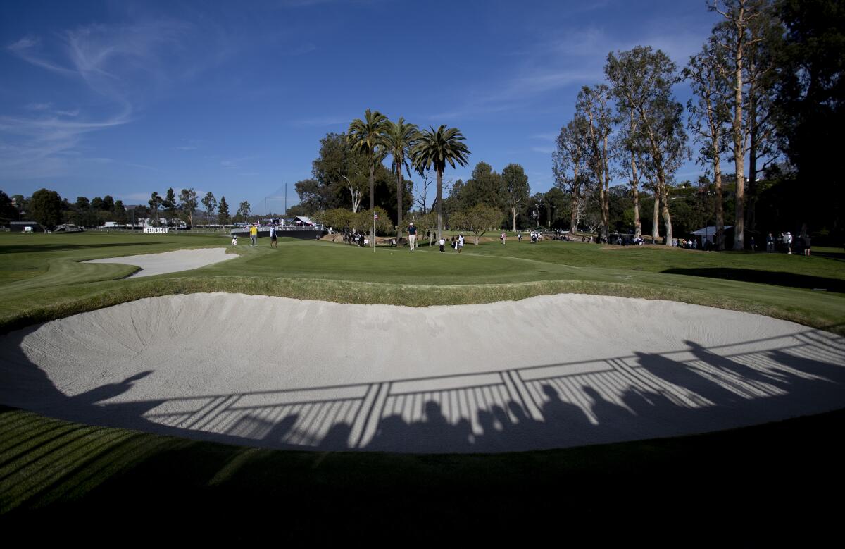 Shadows of the gallery fall into one of the many sand traps surrounding the 10th hole during Round 1 of the Genesis Invitational at Riviera Country Club.