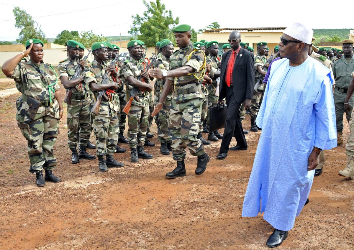 Mali's President Ibrahim Boubacar Keita, right, reviews troops in Kati, near Bamako.