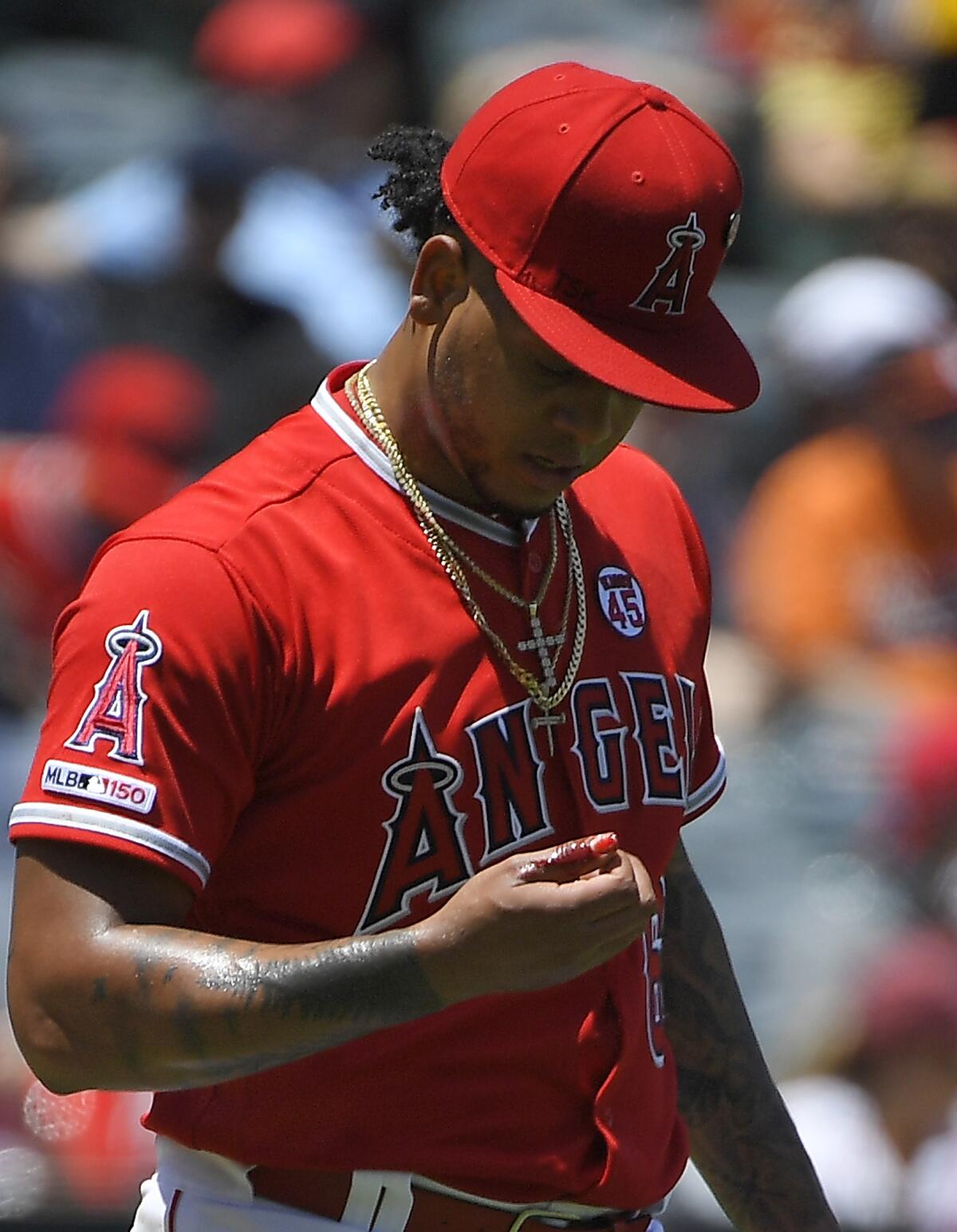 Angels starting pitcher Felix Pena looks at his bleeding thumb during the second inning of Sunday's 5-4 victory over the Baltimore Orioles.