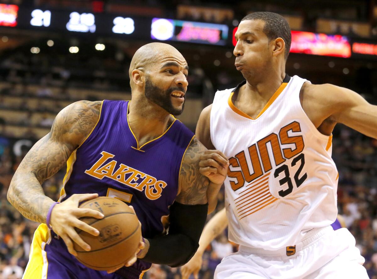Lakers power forward Carlos Boozer, who played at Duke, battles against former North Carolina power forward Brandan Wright in the first half of the Suns/Lakers matchup.