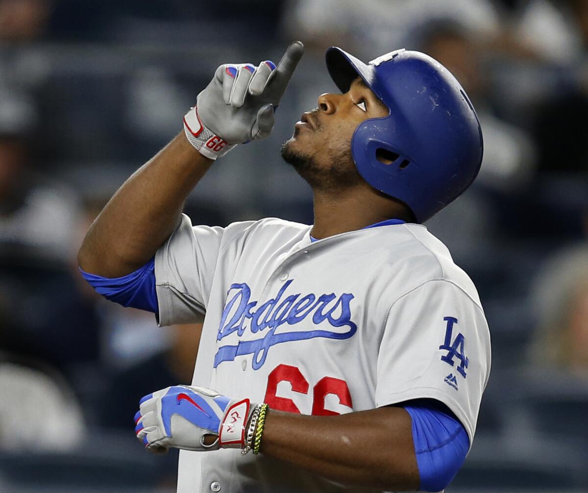 The Dodgers' Yasiel Puig points skyward after hitting a solo home run in the eighth inning against the New York Yankees on Monday.
