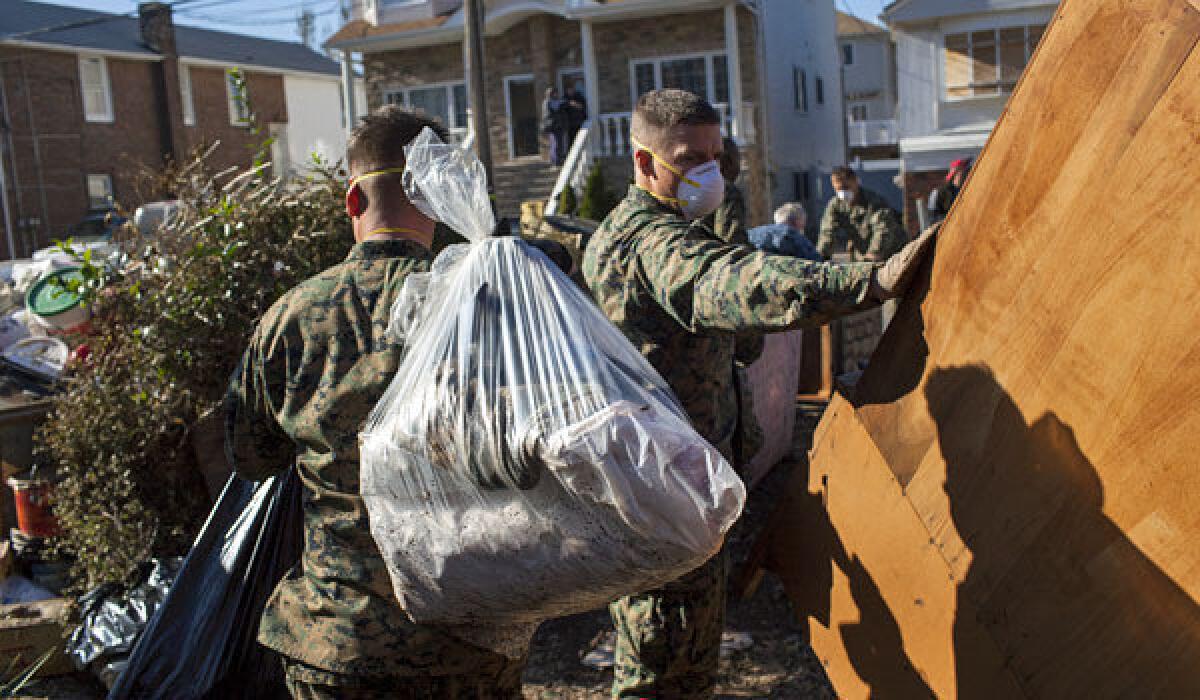 Marines from the 26th Marine Expeditionary Unit and U.S. Navy seamen offer assistance to local residents removing household items damaged by Superstorm Sandy on Staten Island, N.Y.