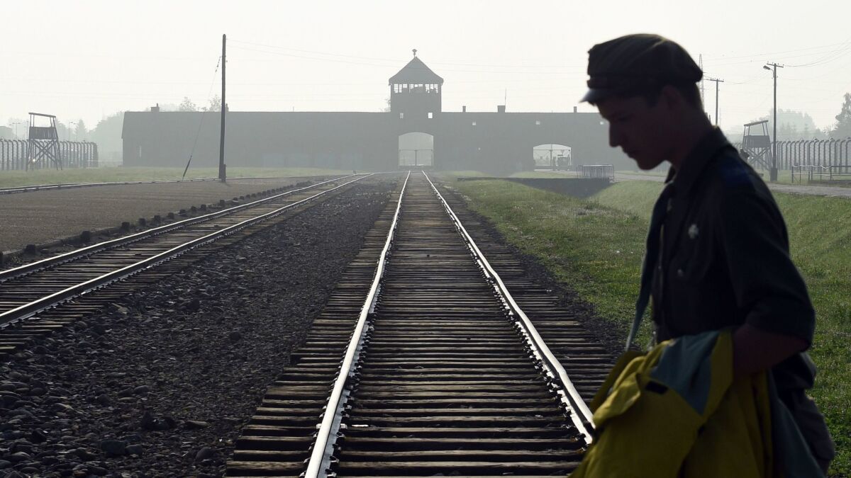 A man crosses the iconic rails leading to the former Nazi death camp of Auschwitz-Birkenau prior to a visit by Pope Francis, in Poland, in July 2016.