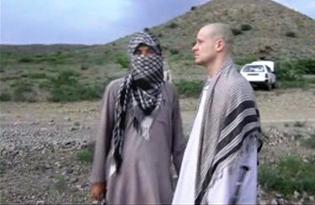 In this image taken from video obtained from Voice Of Jihad website, Sgt. Bowe Bergdahl, right, stands with a Taliban fighter in eastern Afghanistan. The Taliban on Wednesday, June 4, 2014, released a video showing the handover of Bergdahl to U.S. forces in eastern Afghanistan, after five years in captivity.