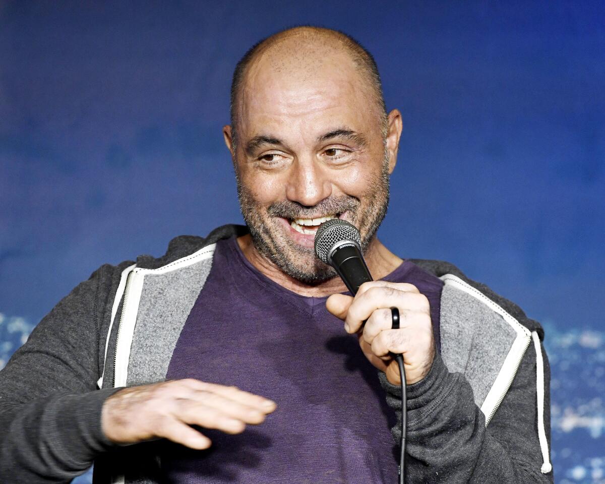 Joe Rogan holds a microphone