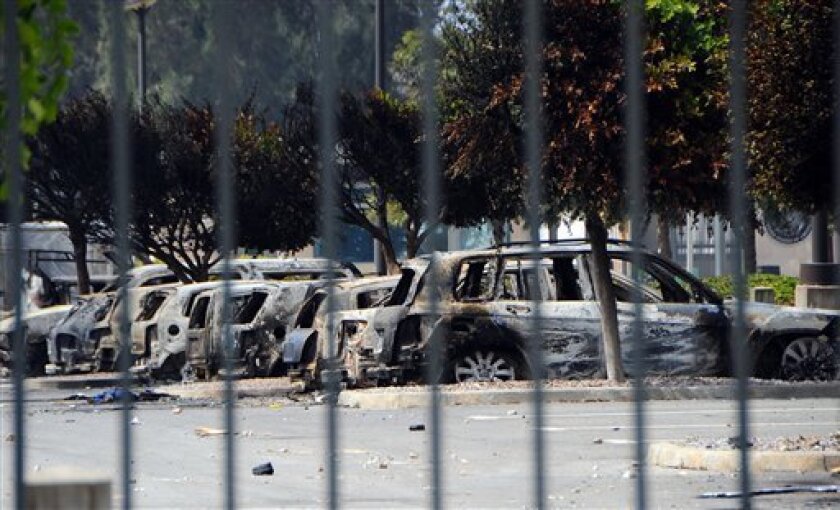 View of several dozen burned cars in the parking lot of the U.S. Embassy, a day after several thousand demonstrators angry over a film that insults the Prophet Muhammad stormed the compound, Tunis, Tunisia, Saturday, Sept. 15, 2012. Tunisia's governing moderate Islamist party condemned an attack on the U.S. Embassy in Tunis and the neighboring American school, saying Saturday that such violence threatens the country's progress toward democracy after decades of dictatorship. (AP Photo/Hassene Dridi)