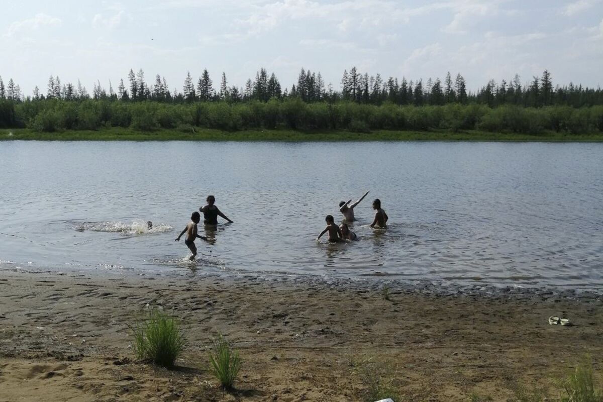 Children play in a lake near the Siberian town of Verkhoyansk, where the temperature reached 100.4 degrees Saturday.