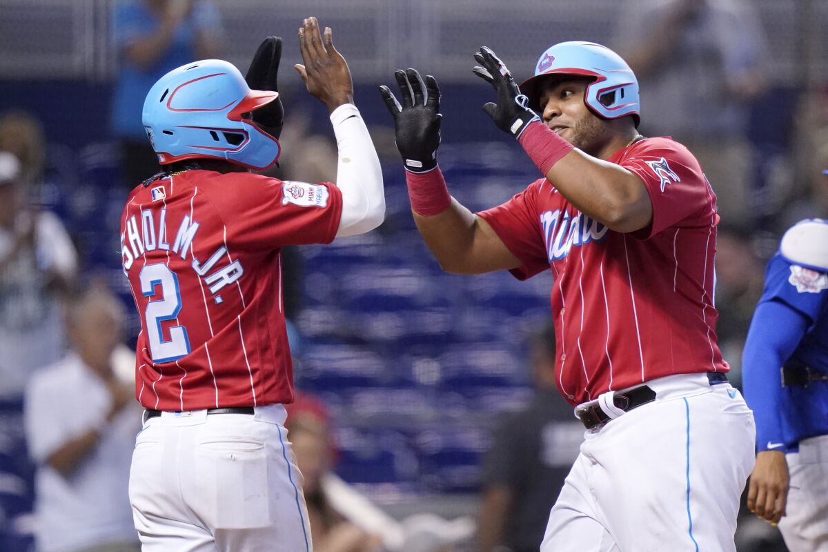 Miami Marlins' Jazz Chisholm Jr. (2) greets Jesus Aguilar after they scored on a two-run home run hit by Aguilar during the eighth inning of a baseball game against the Chicago Cubs, Sunday, Aug. 15, 2021, in Miami. (AP Photo/Lynne Sladky)
