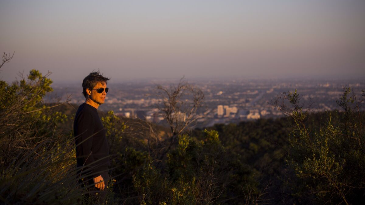 Investor and philanthropist Nicolas Berggruen, 54, looks west at sunset from atop a peak on the 450 acres he purchased in the Sepulveda Pass.
