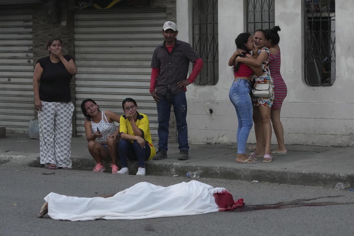 Varias personas lloran junto al cadáver de un hombre, asesinado